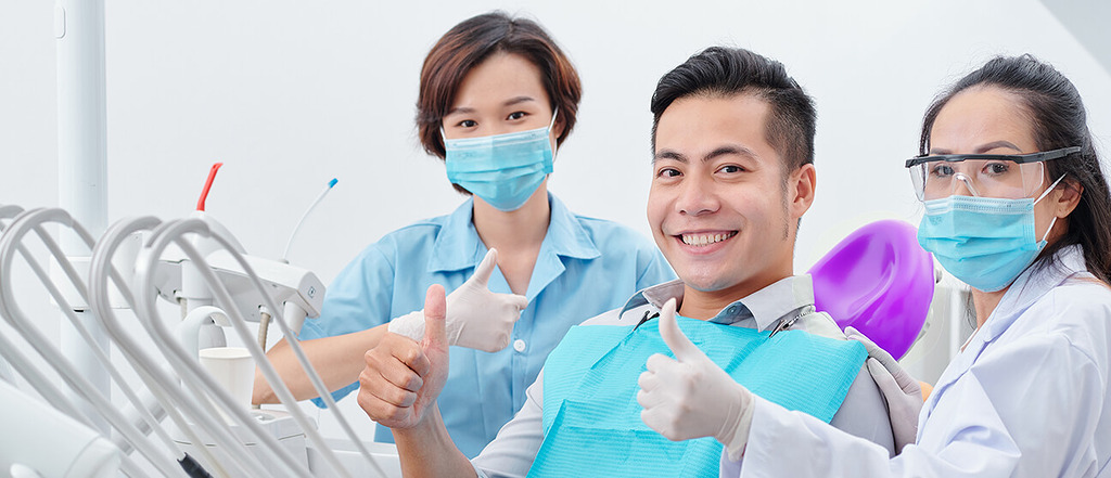 Bác sĩ và phụ tá Nha Khoa Cẩm Tú điều trị bệnh nhân trên ghế nha khoa tại Nha khoa Cẩm Tú Nha khoa Quận 1